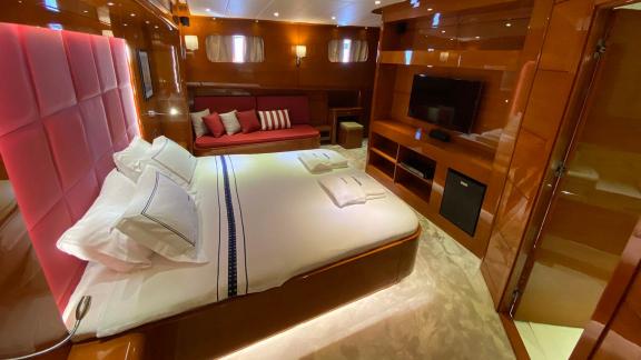 Guest cabin with double bed, sofa, and TV on yacht Gül Maria